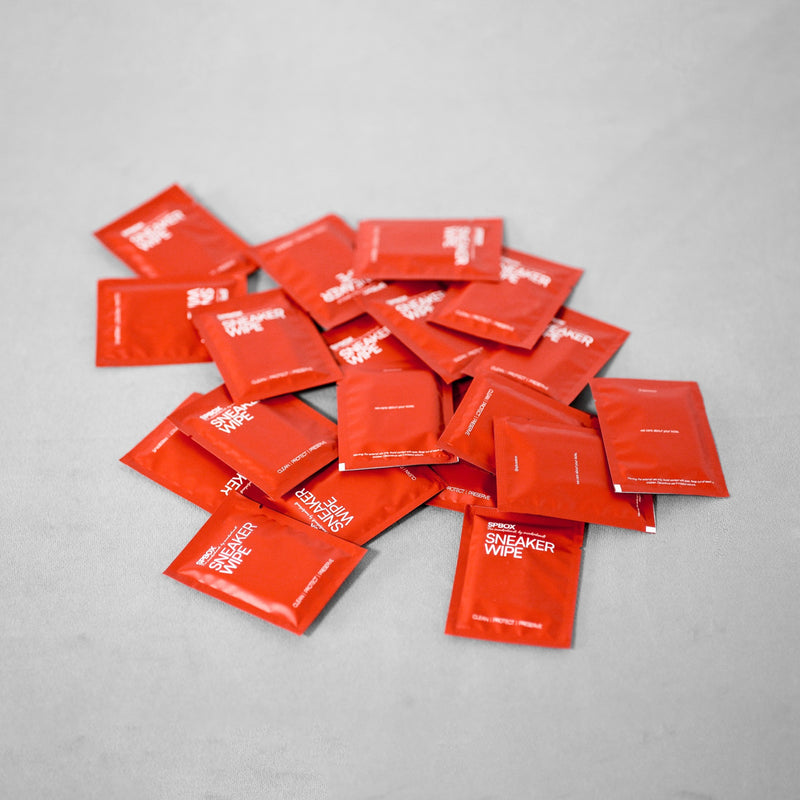 SPBOX sneaker wipe sachets scattered on a grey surface